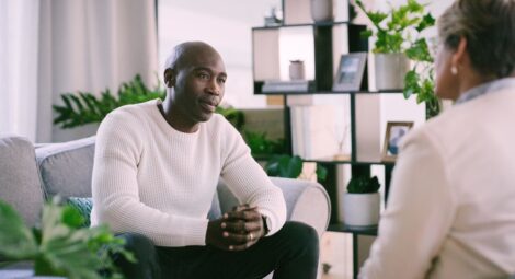 Man sitting on a couch across from a therapist