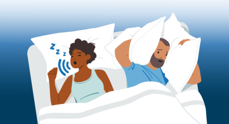 Man covers ears with a pillow as woman snores next to him