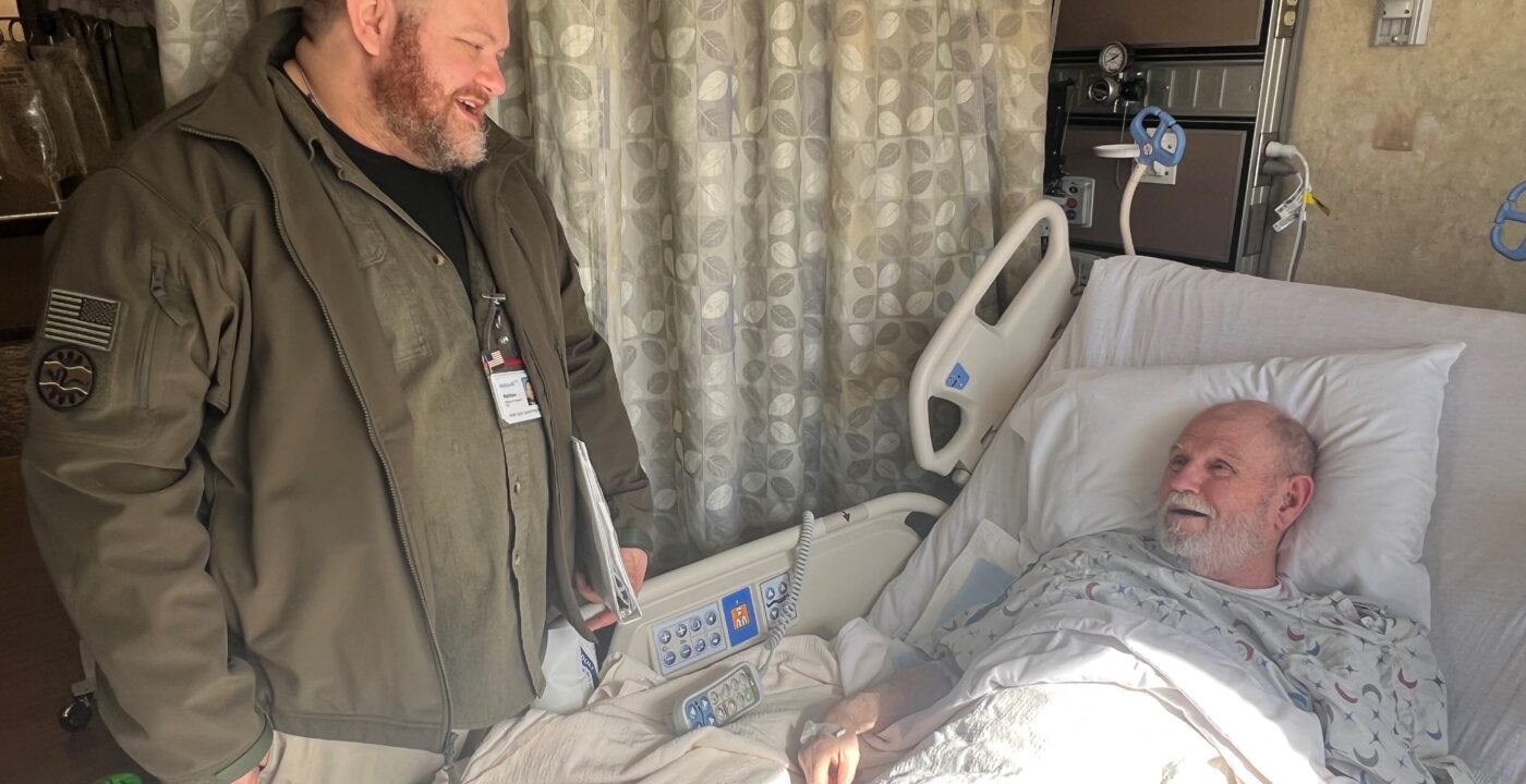 Hospital employee talking to patient in a hospital bed