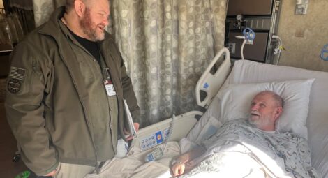 Hospital employee talking to patient in a hospital bed