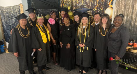 Group of people wearing graduation caps and gowns standing together