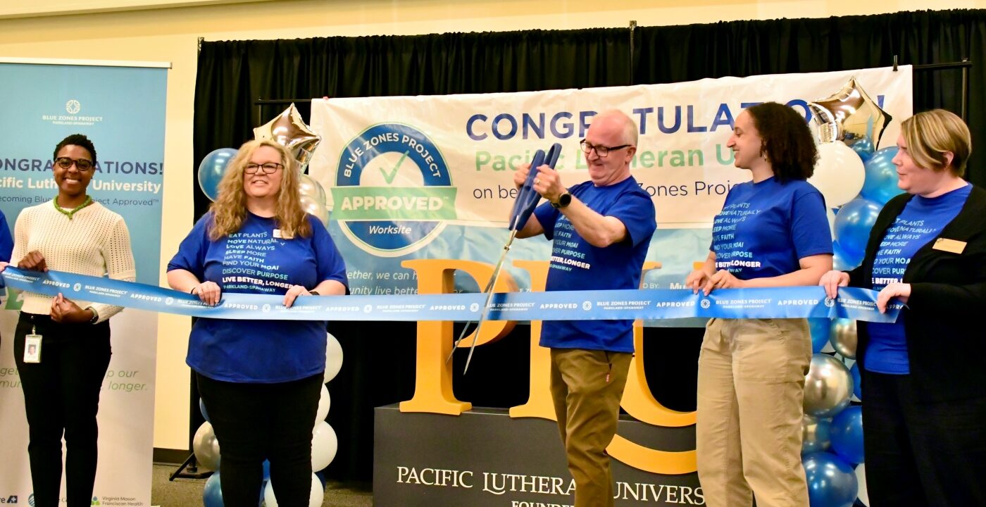 Man cuts ribbon with large scissors