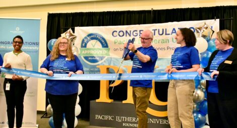 Man cuts ribbon with large scissors