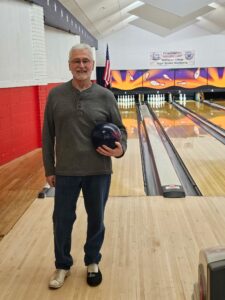 man holding bowling ball in bowling lane