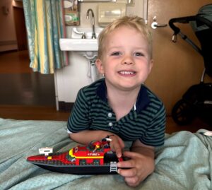 Young boy shows off Lego set in hospital room