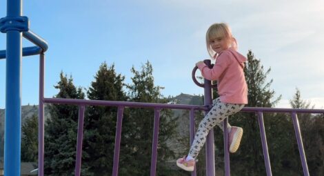 Little girl climbing on playground equipment