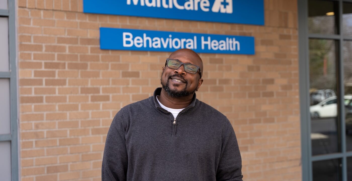 Man posing in front of a MultiCare sign.