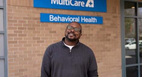 Man posing in front of a MultiCare sign.