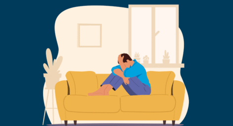Man on couch with head in hands