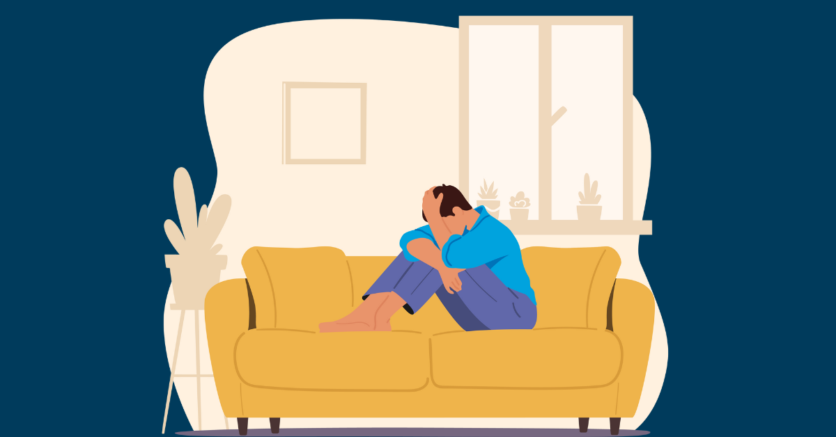 Man on couch with head in hands