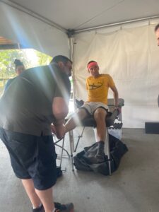 man examines ankle of man sitting on medical bed, Woelber was treated at the MultiCare medical tent at Hoopfest after rupturing his Achilles tendon during a game.