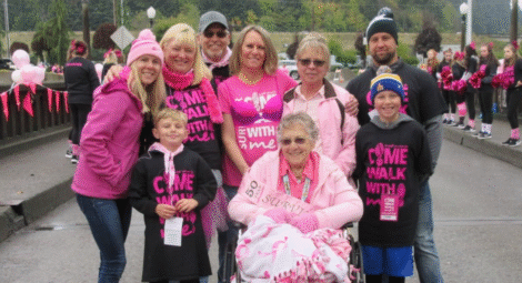 Family dressed in pink and Come Walk With Me shirts poses for a photo