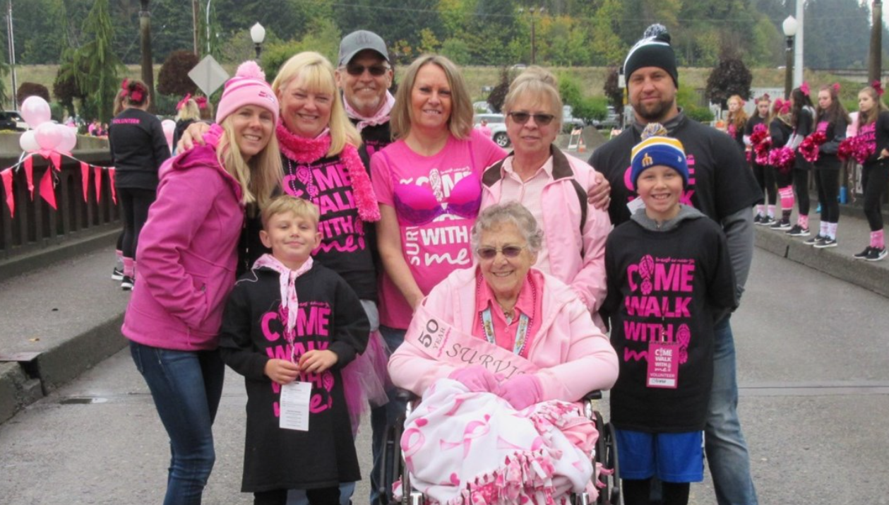 Family dressed in pink and Come Walk With Me shirts poses for a photo