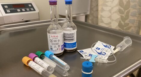 Tools and vials to collect blood sit on table