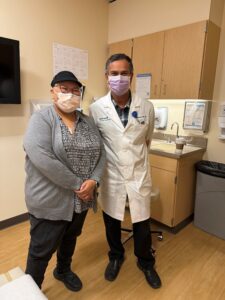woman stands next to her doctor