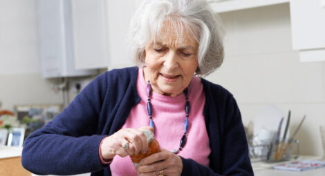elderly woman struggling to open jar