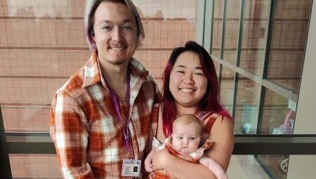 A couple holding a baby