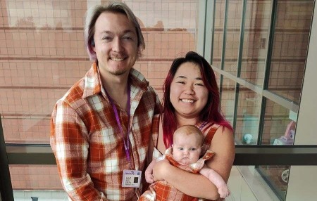 A couple holding a baby