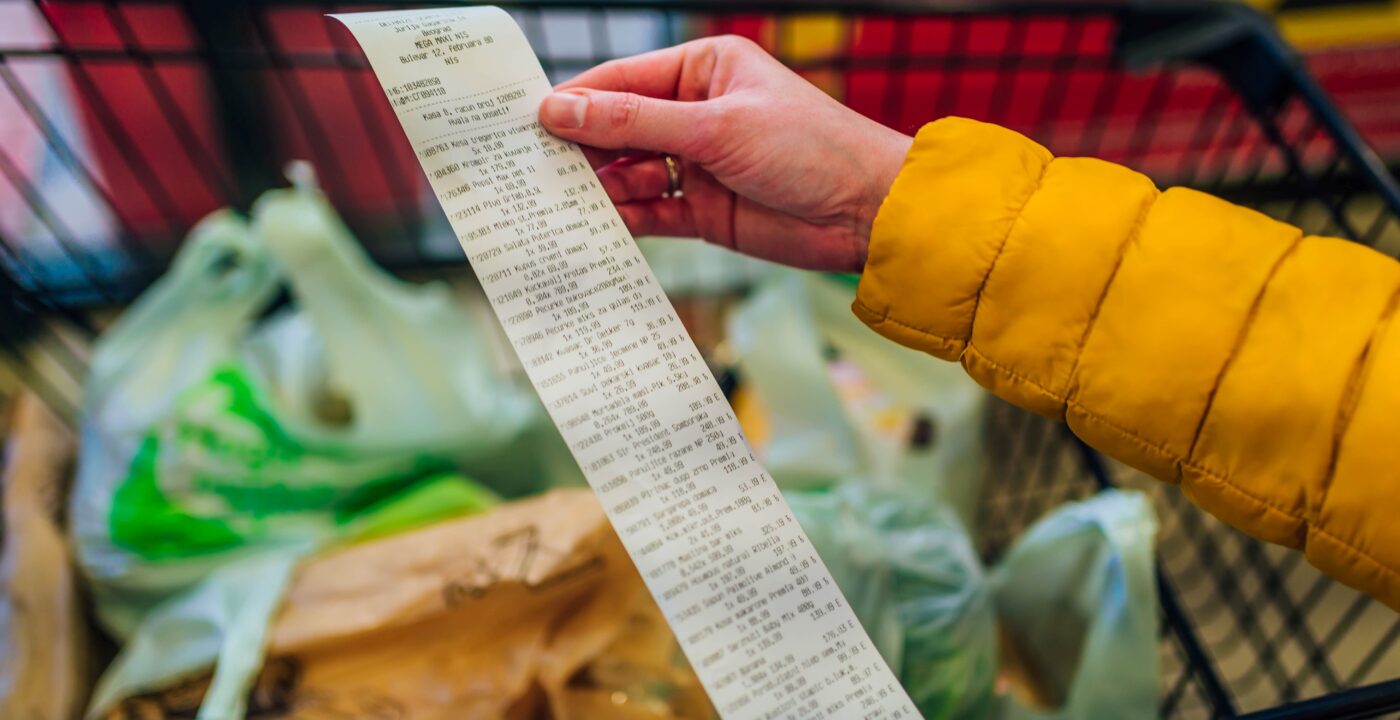Grocery shopper looking at long receipt
