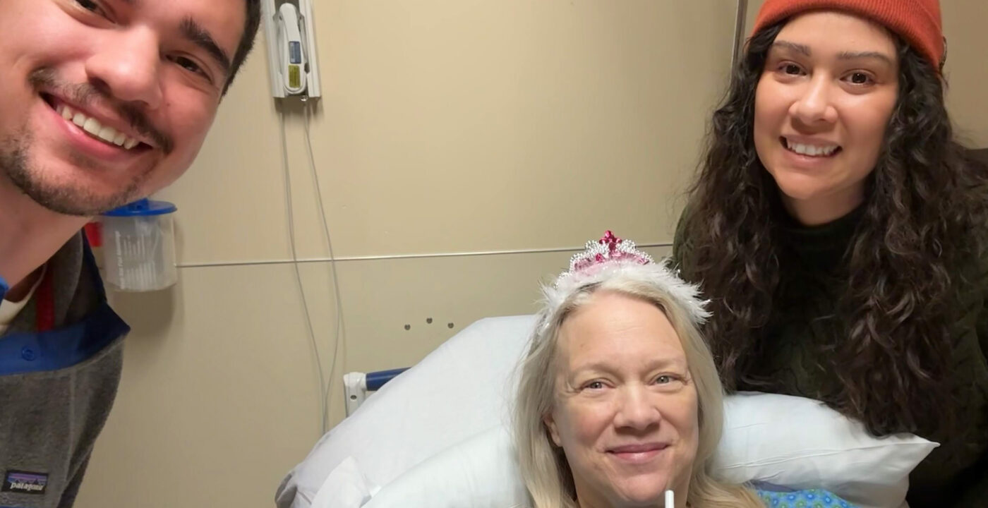 woman in hospital bed wearing tiara with son and daughter