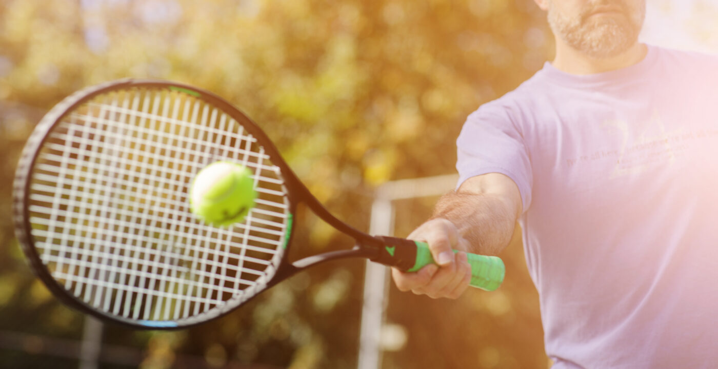 man hitting ball with tennis racket