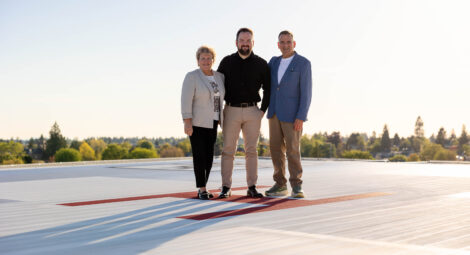 Three people standing on a rooftop helipad