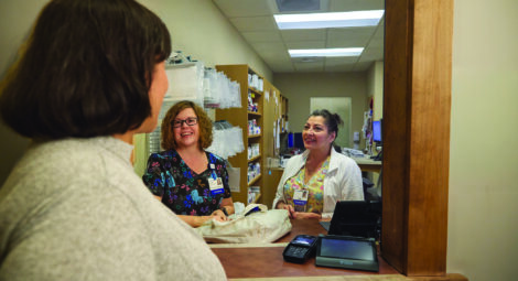 Three women talking at pharmacy window