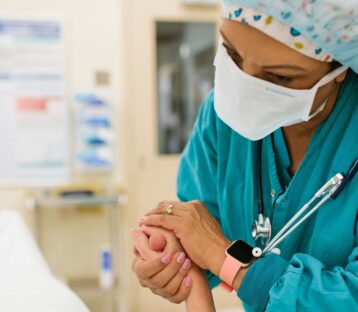 Nurse holding patient's hand