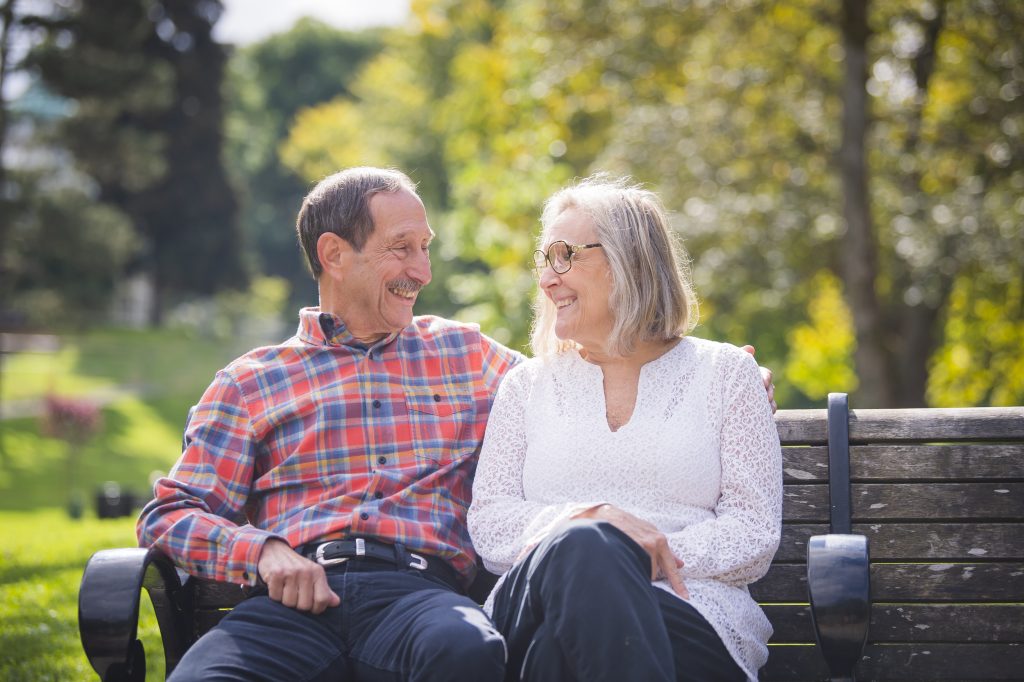 Older man and woman sitting on bench