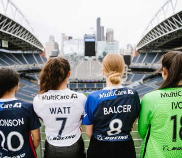 Four women in sports jerseys