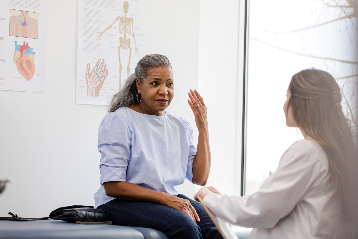 Woman on a medical table talking to her doctor.