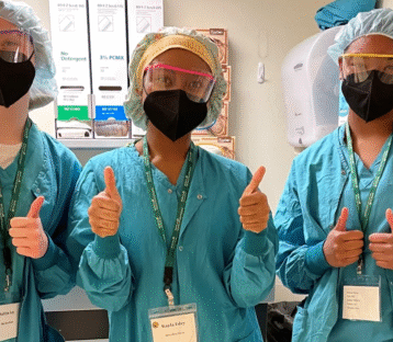 Gowned students giving the thumbs up.