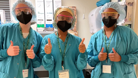 Gowned students giving the thumbs up.