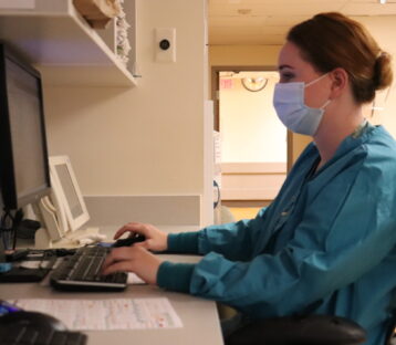 Nurse working at computer station in hospital