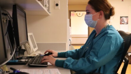 Nurse working at computer station in hospital