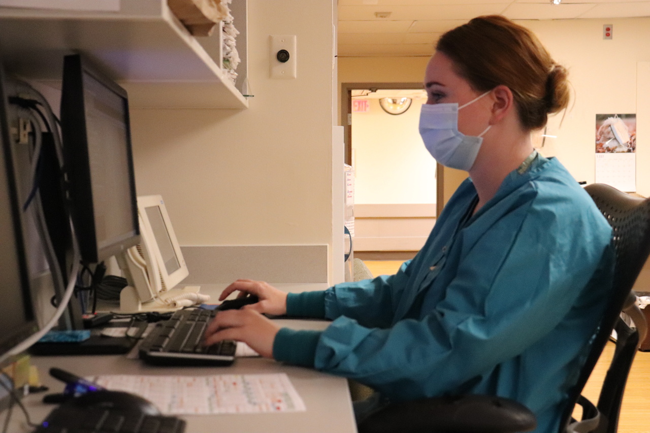 Nurse working at computer station in hospital