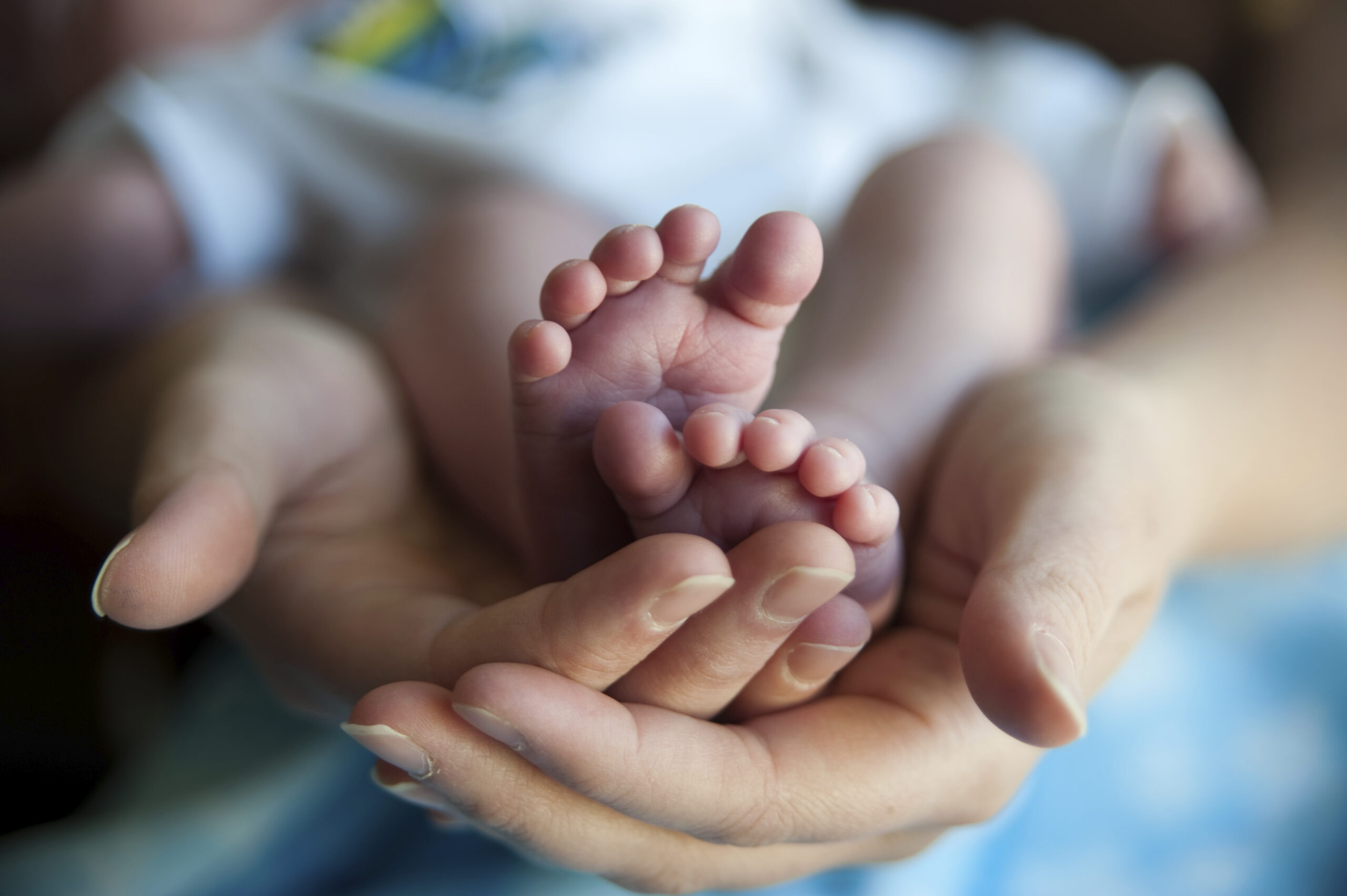 Woman holding baby showing feet