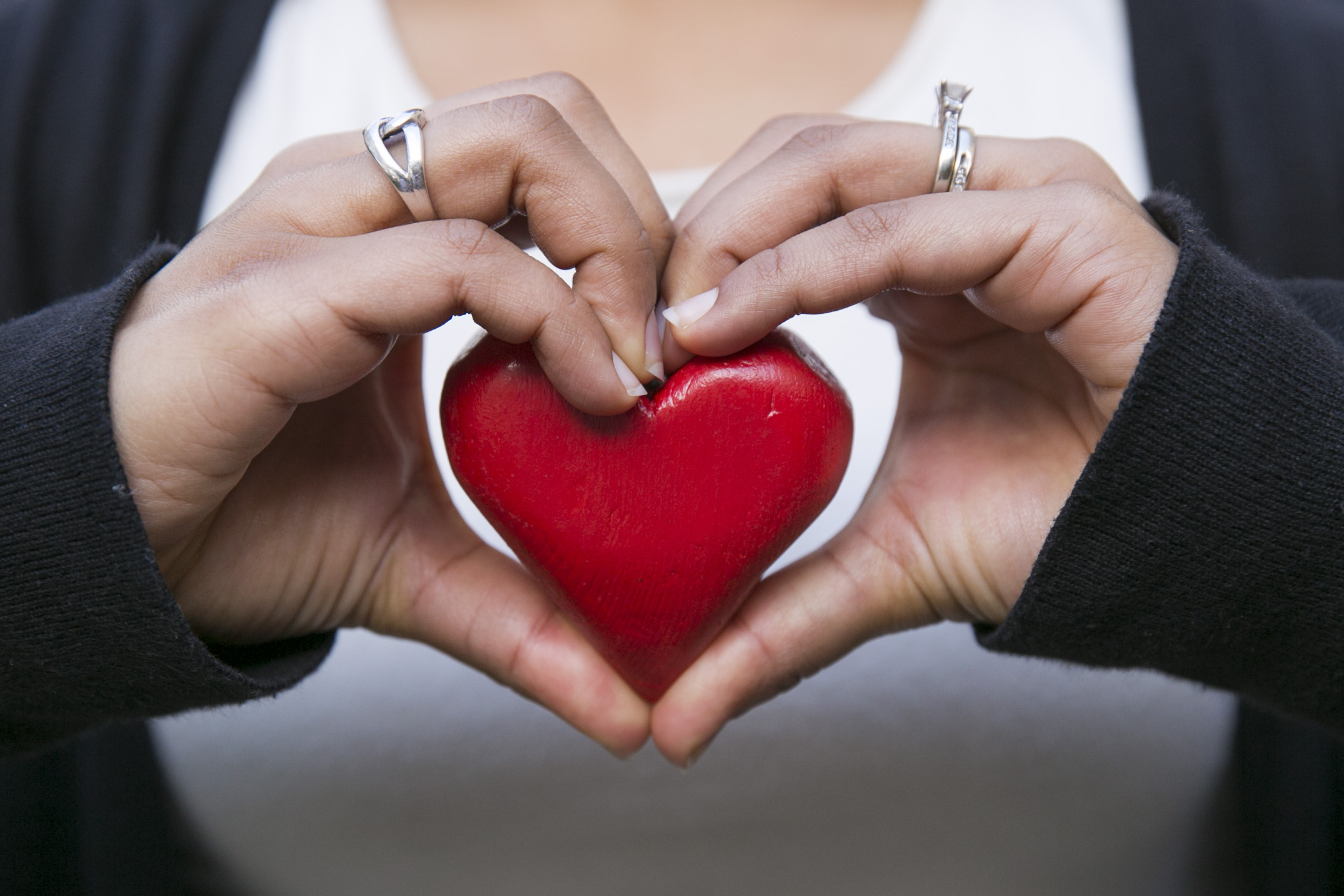 Hands around a heart shape.