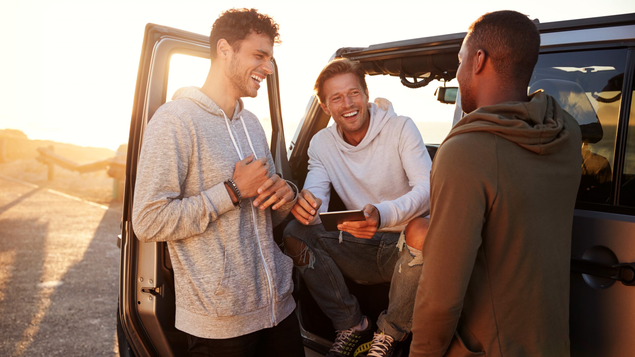 Three men standing near a car