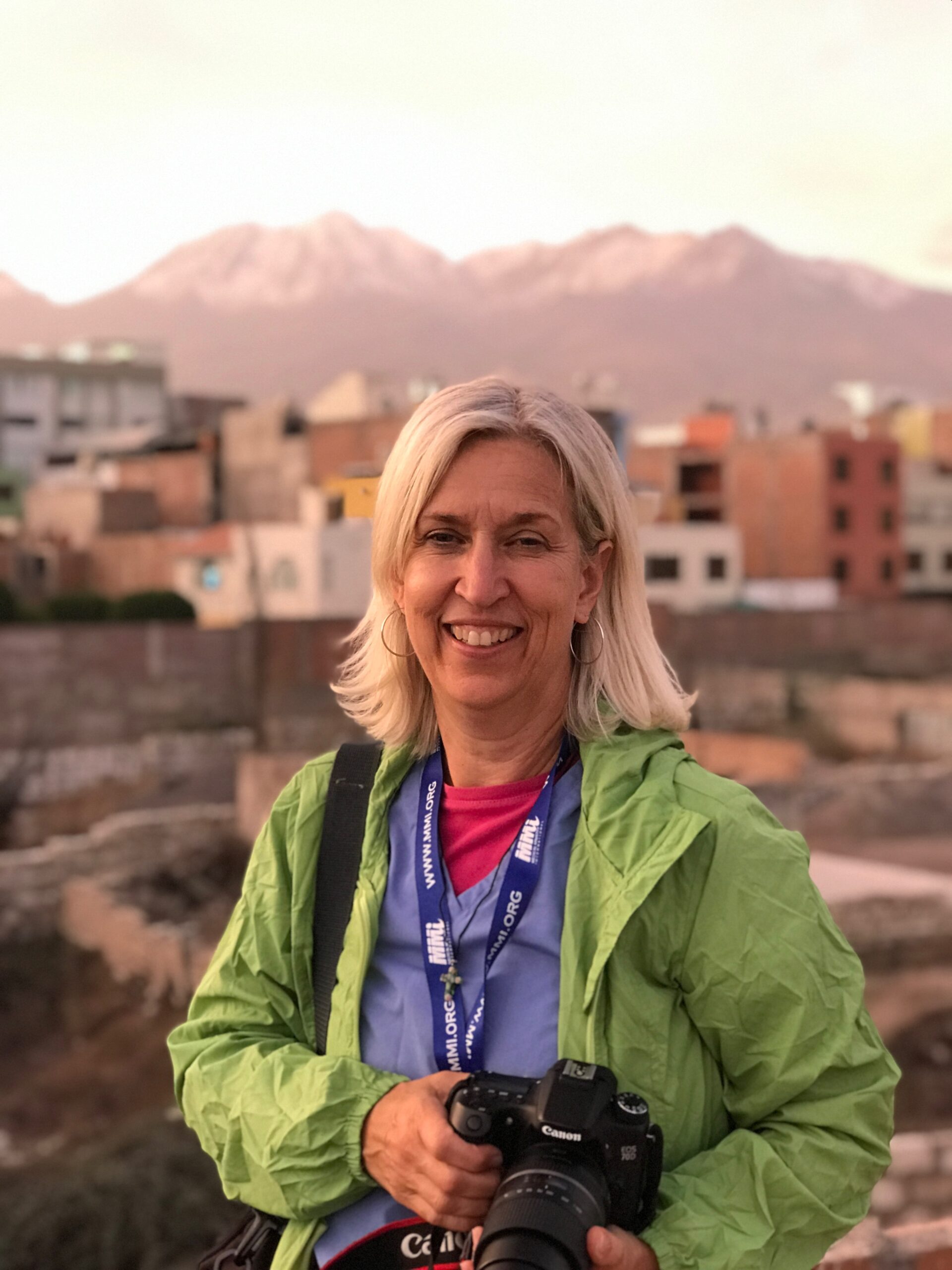 Woman wearing a green jacket and holding a camera