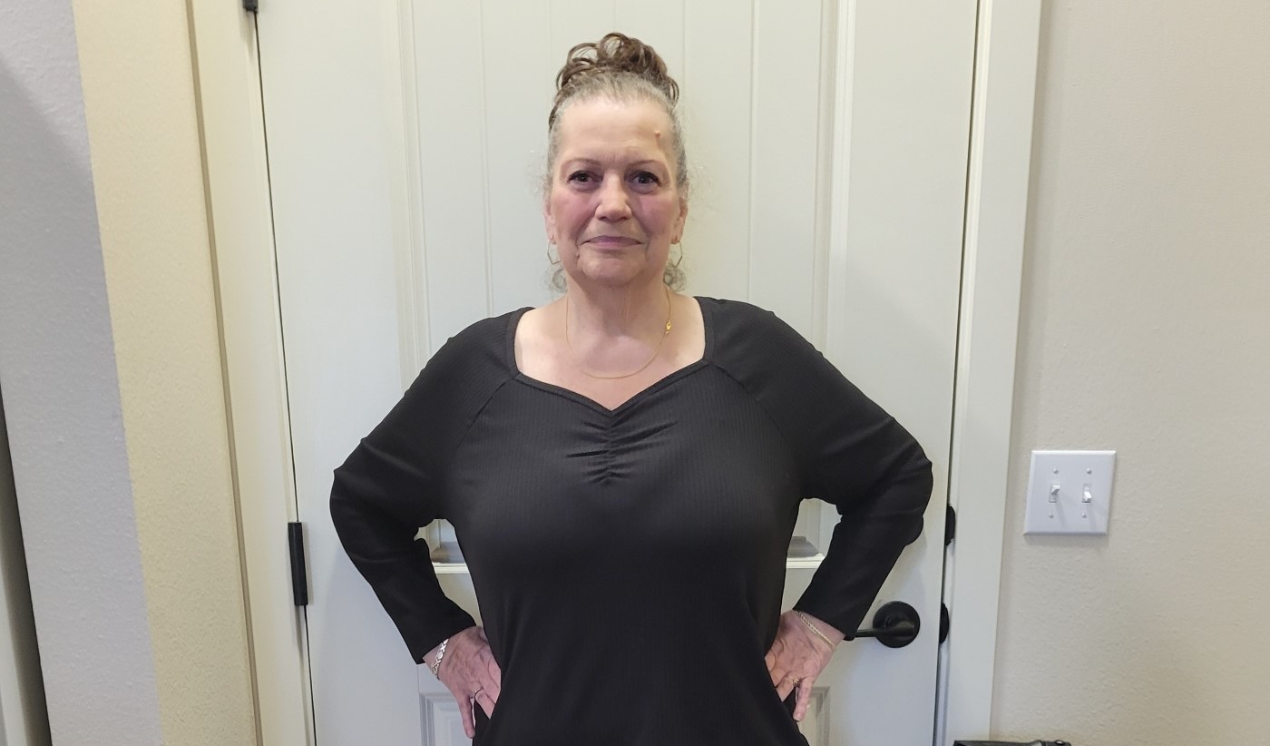 Woman posing to show weight loss.