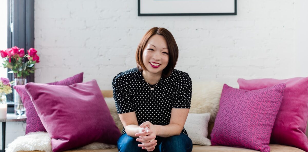 Tamara Chang, MD, sits on a couch with pink pillows