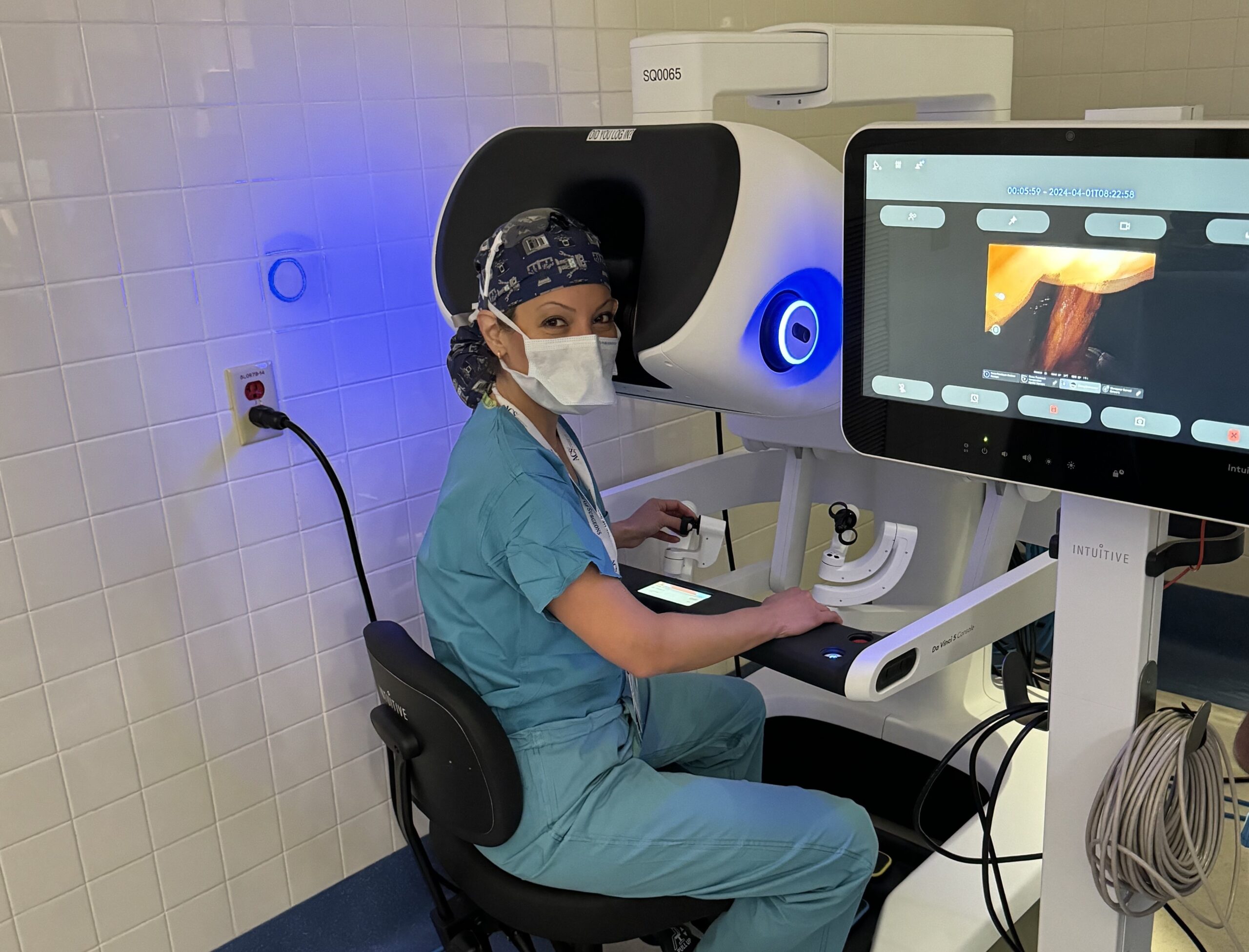 Surgeon sitting at the console of a surgical robot during a patient procedure
