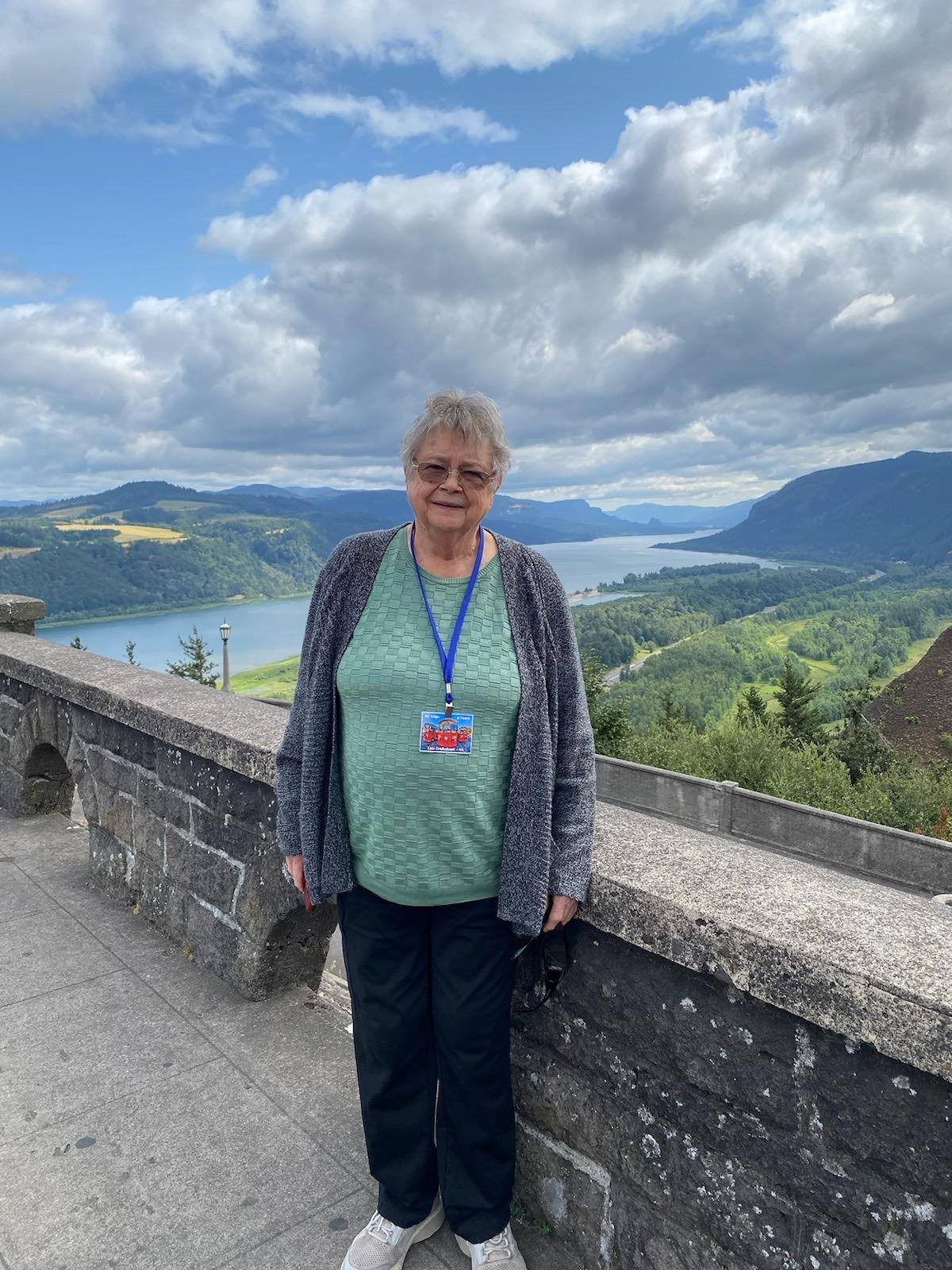 woman standing in front of scenic river viewpoint