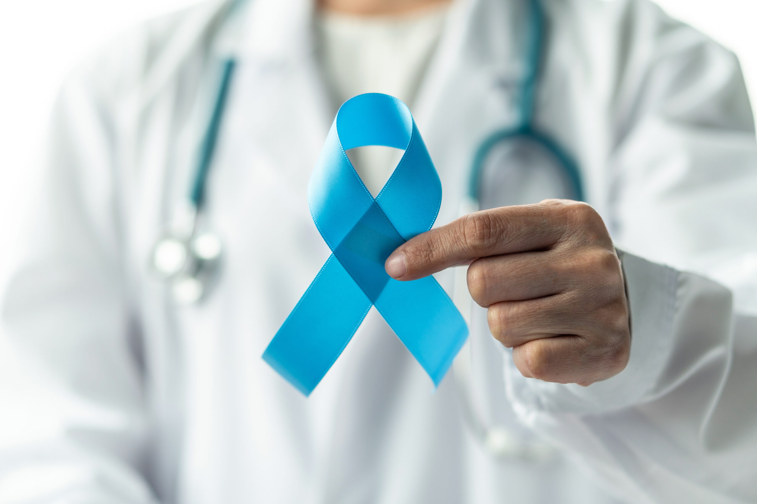 Hand holding a blue ribbon.