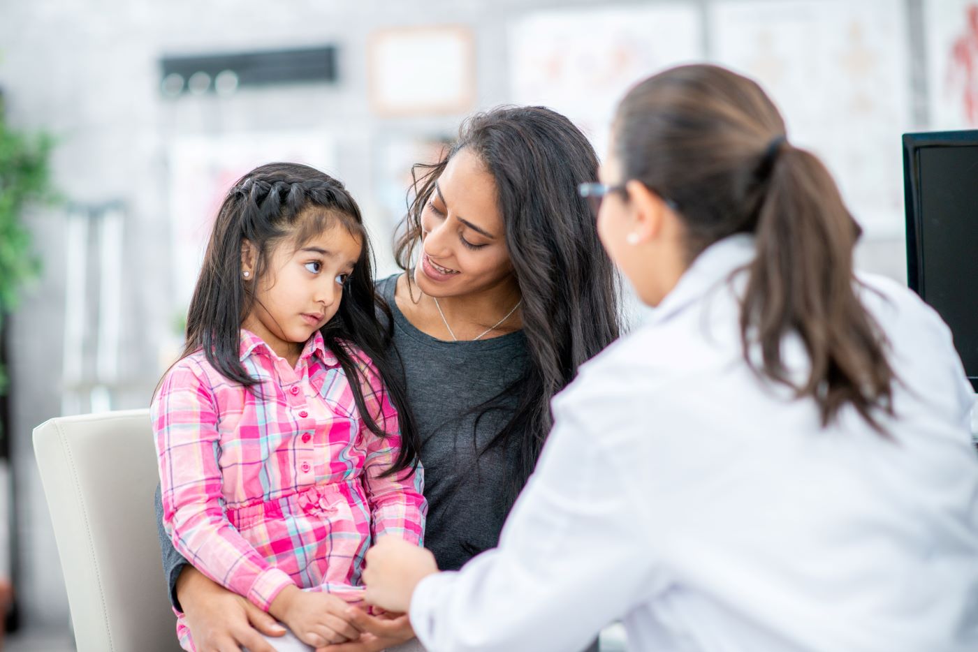 Mother and her young daughter talking with a provider