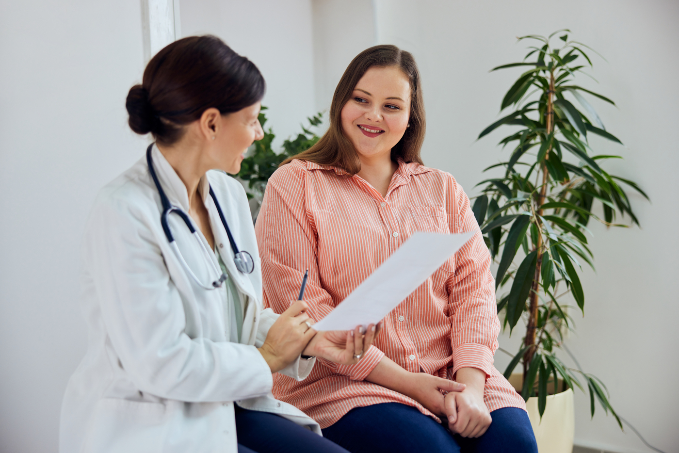 woman in blue striped shirt smiling at doctor