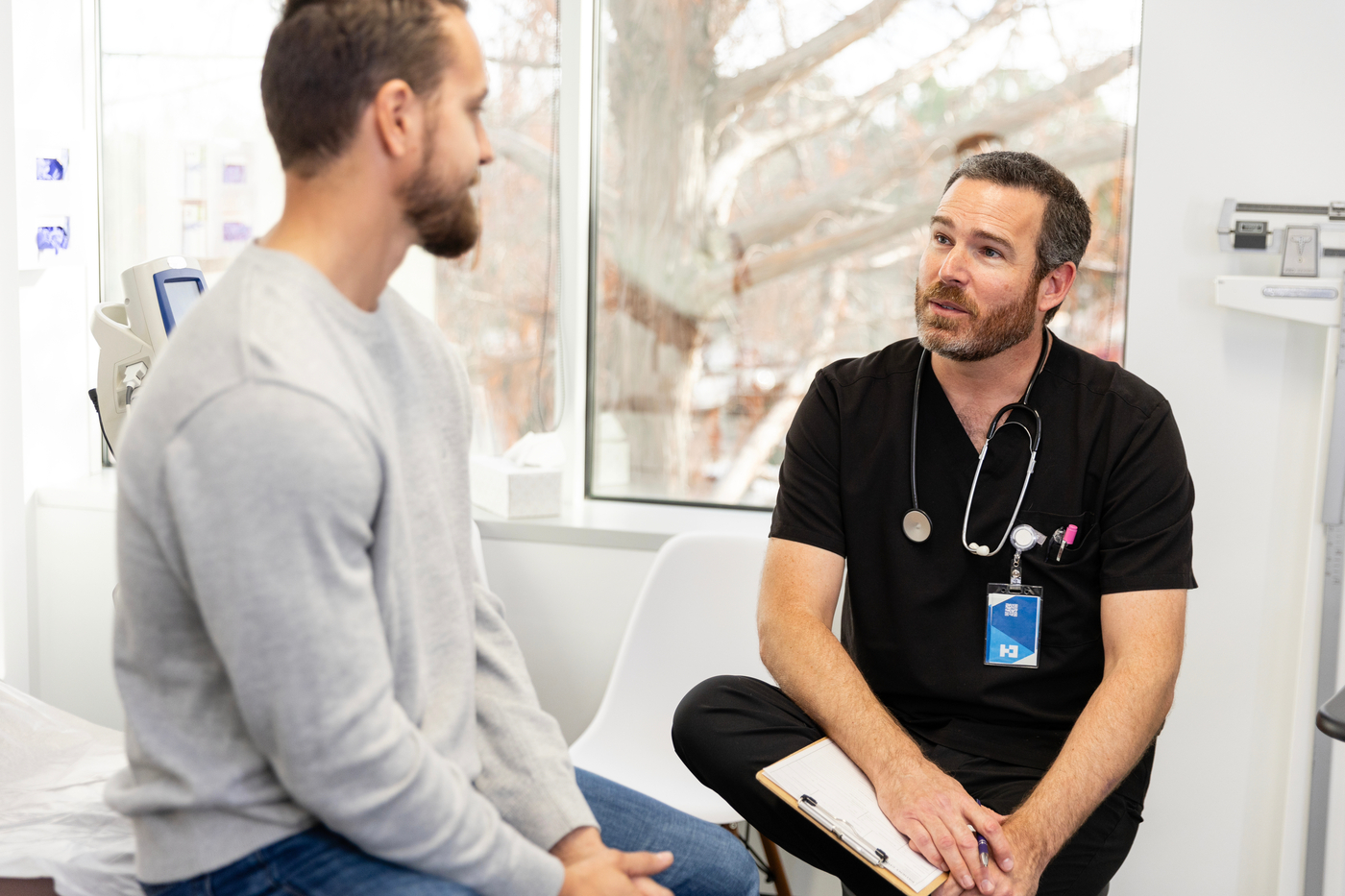 Male patient talking to medical provider in exam room