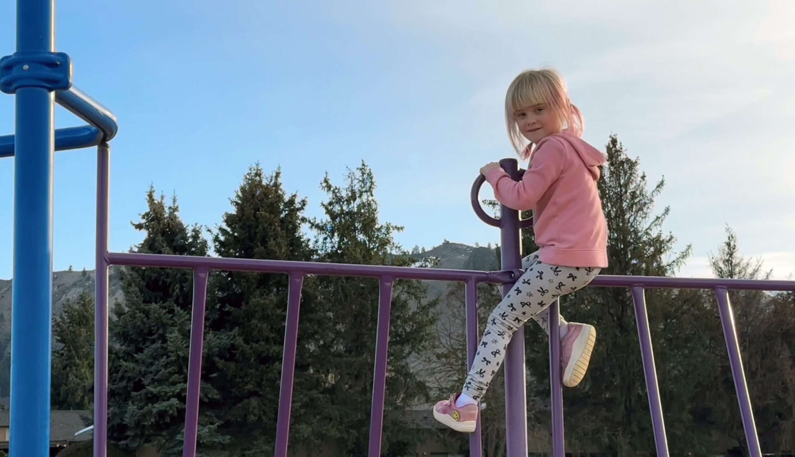 Little girl climbing on playground equipment