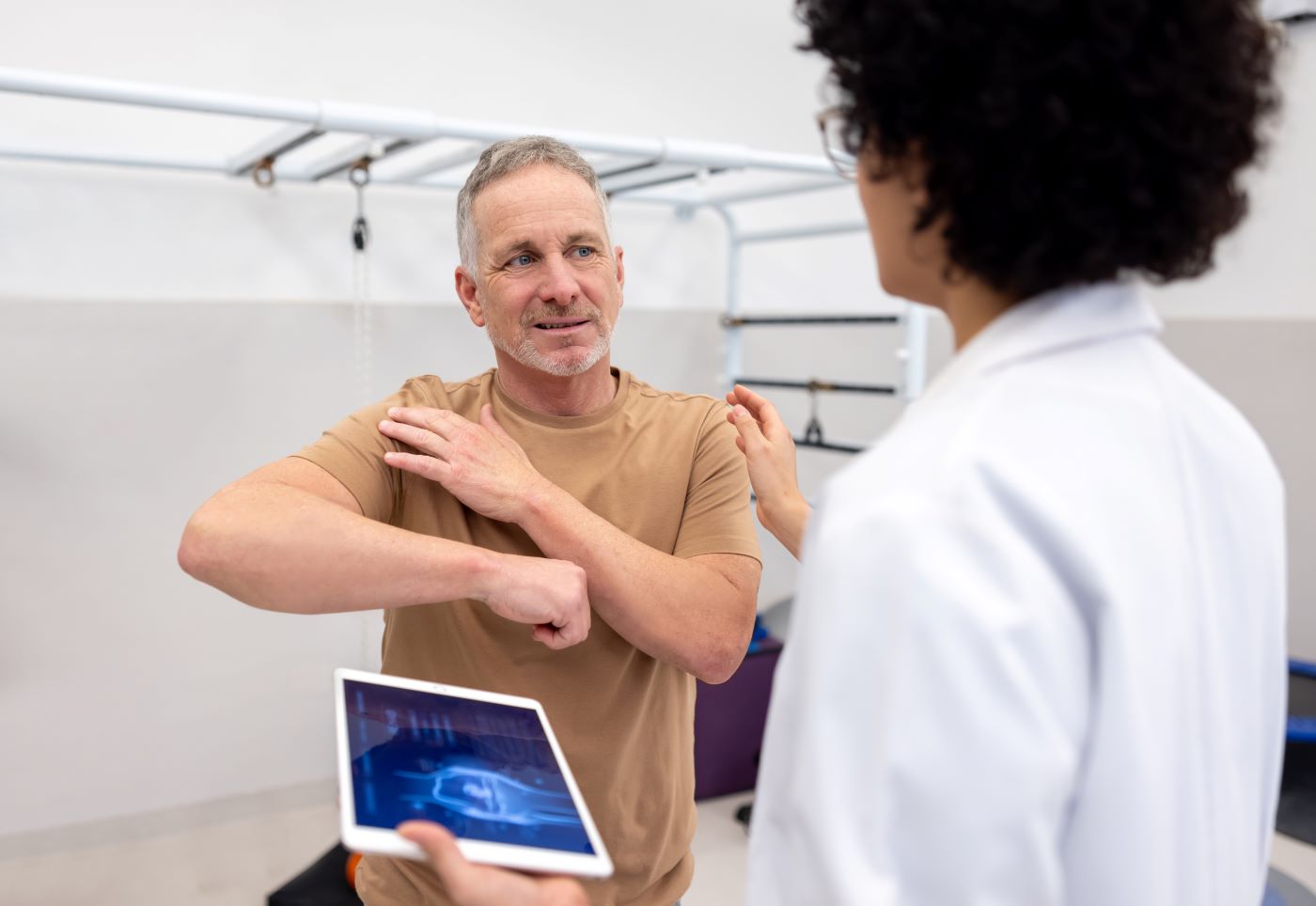 man shows doctor where shoulder hurts